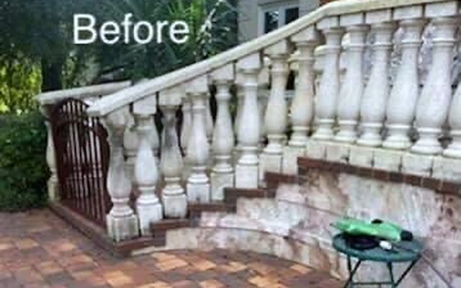 Outdoor masonry patio and balustrade with visible buildup before cleaning.