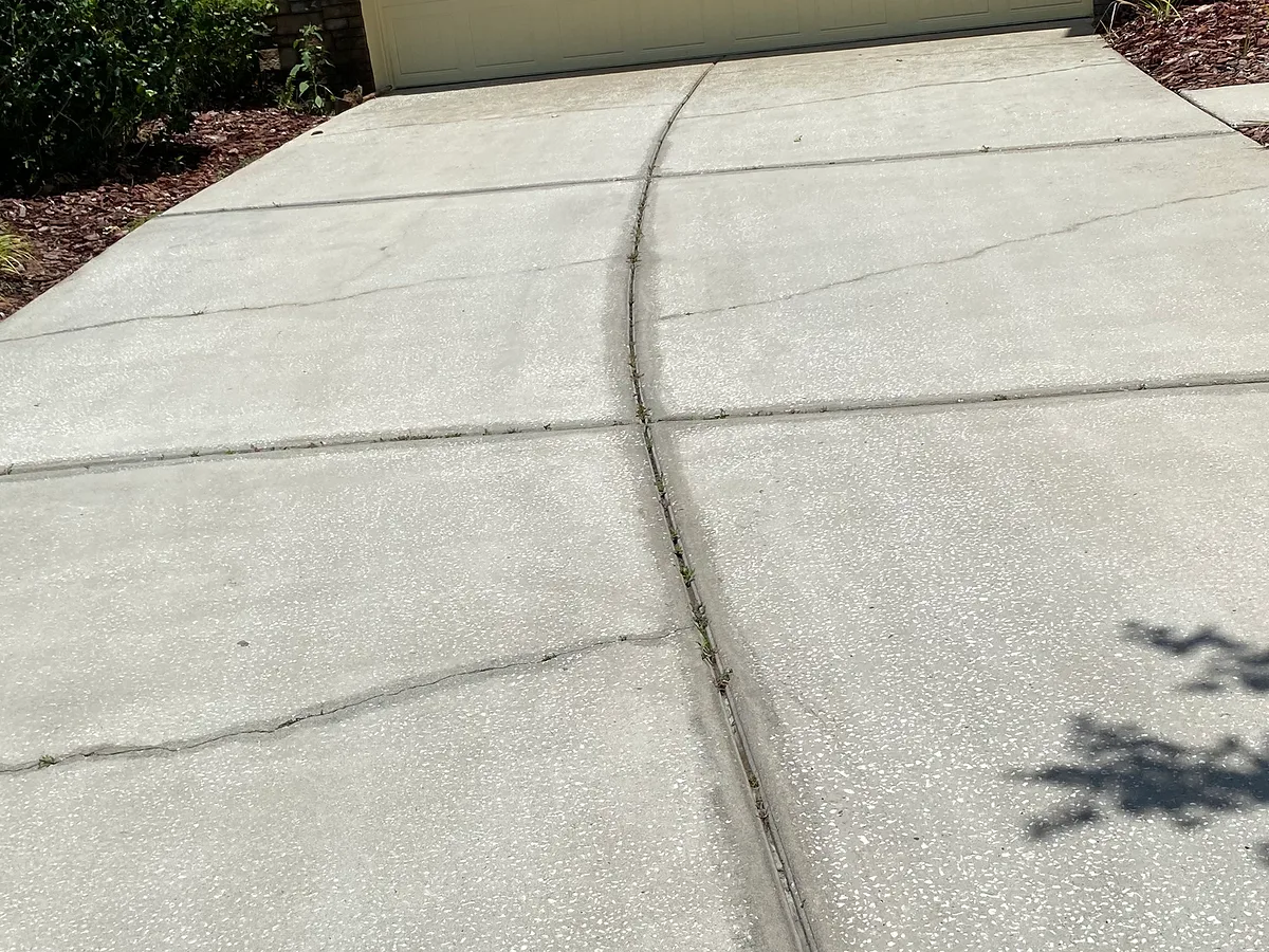 The same driveway after cleaning, with existing cracks still visible.